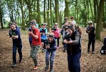 Group of players participating in outdoor laser tag in a wooded area